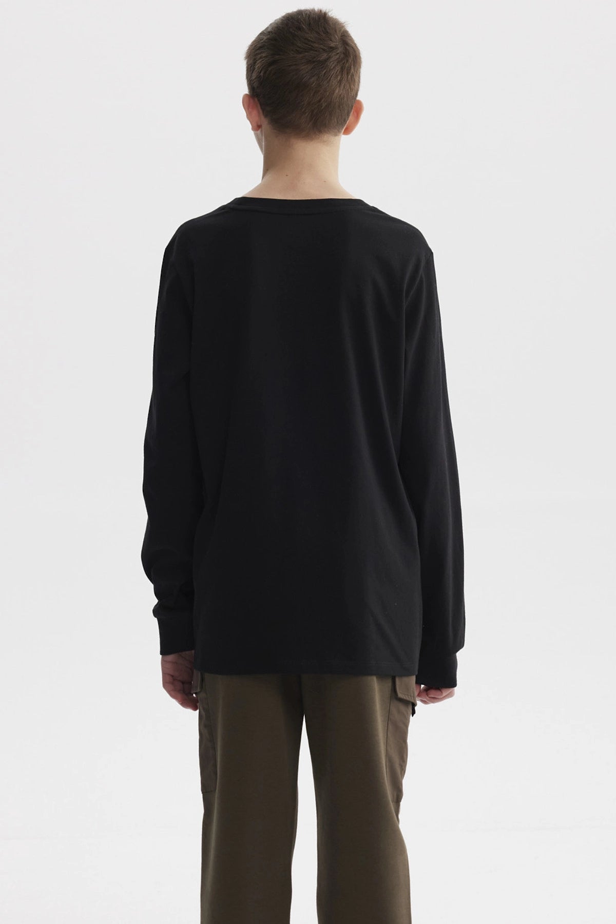 Polera negra de niño con estampa 'NYC SPORTS NY 1898' en el pecho estilo casual y urbano sin estampas adicionales