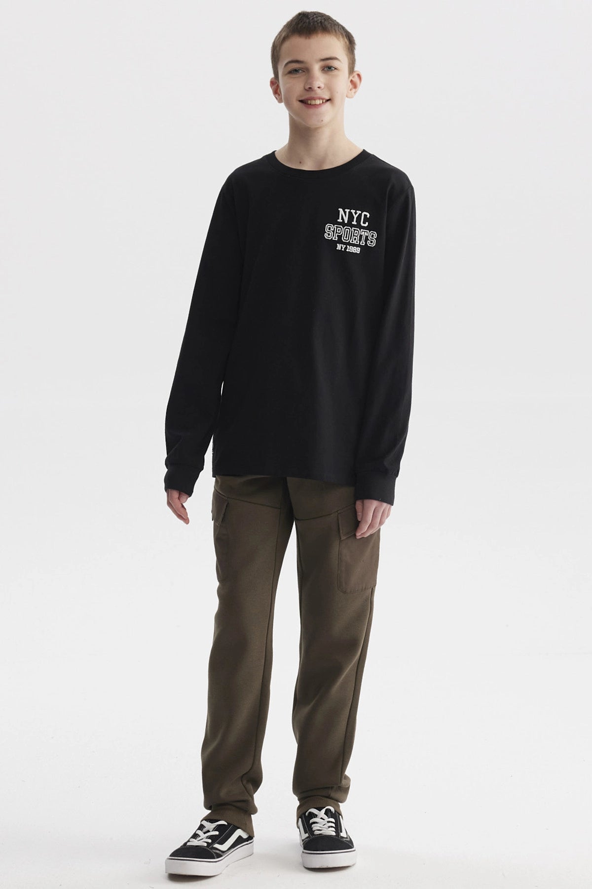 Polera negra de niño con estampa 'NYC SPORTS NY 1898' en el pecho estilo casual y urbano sin estampas adicionales