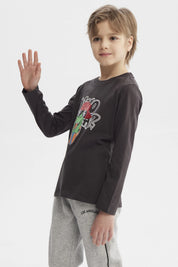 Polera de niño marengo con estampado de dinosaurio rockero con audífonos y gorra roja en el centro estilo dibujo animado