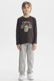 Polera de niño marengo con estampado de dinosaurio rockero con audífonos y gorra roja en el centro estilo dibujo animado