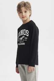 Polera niño negra con estampa blanca de dinosaurio y texto Dinos Epic Team en el pecho estilo universitario casual