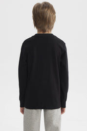 Polera niño negra con estampa blanca de dinosaurio y texto Dinos Epic Team en el pecho estilo universitario casual
