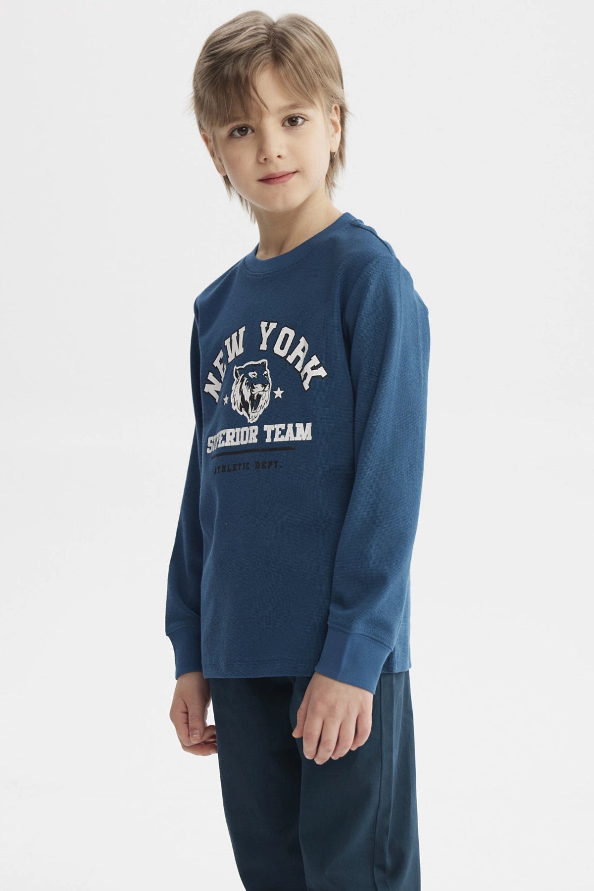 Polera niño azul petróleo con puños y estampa central de tigre y texto New York Superior Team estilo deportivo