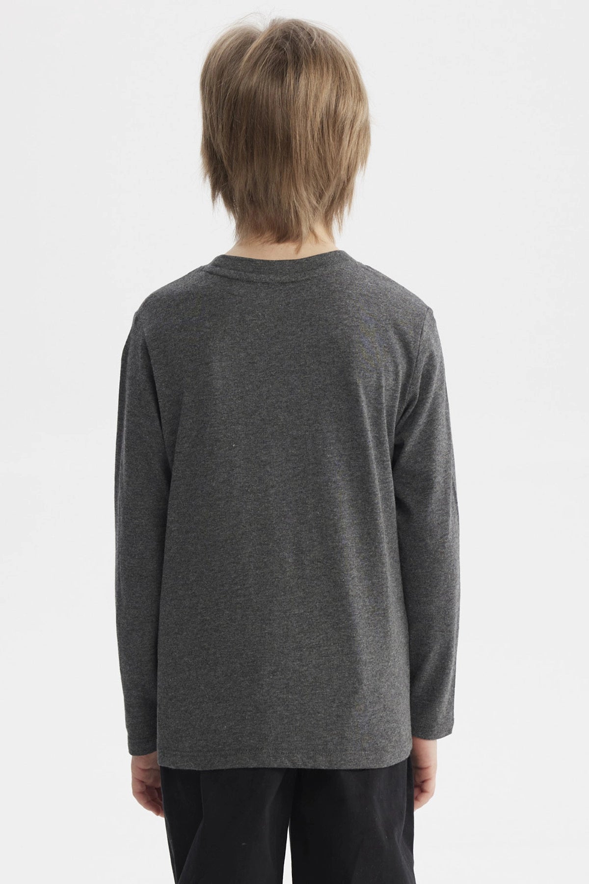 Polera niño gris con parches grandes en el pecho estilo universitario letras amarillas que dicen Extraordinary Education 1973