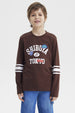 Polera slim café para niño con texto Shibuya Tokyo en el pecho y detalles gráficos urbanos manga larga con rayas blancas