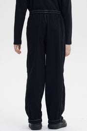 Pantalón niño pitillo negro con costuras visibles y cintura elástica la prenda es lisa