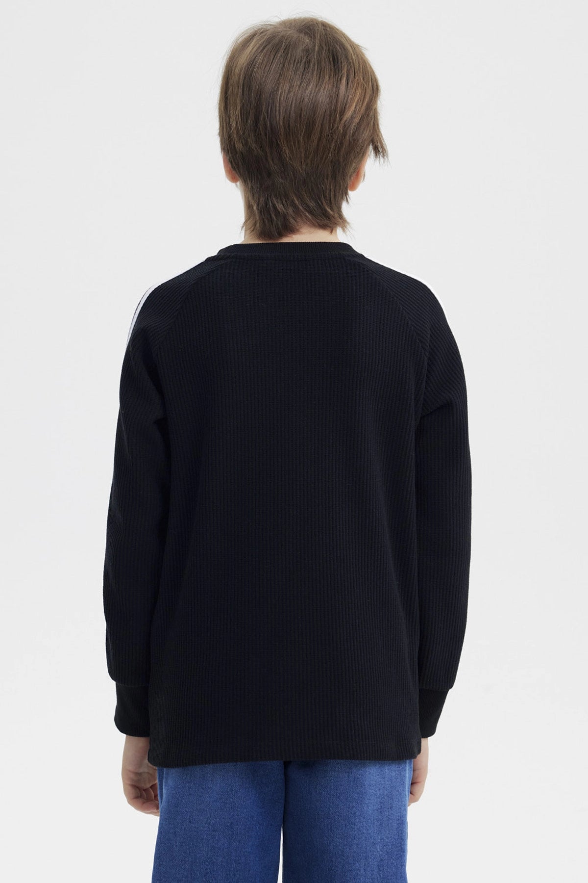 Polera niño negra con textura bicolor con texto True State 8 en el pecho diseño casual con líneas blancas en las mangas