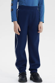 Pantalón buzo pitillo azul oscuro para niño con líneas blancas a los lados prenda lisa