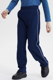 Pantalón buzo pitillo azul oscuro para niño con líneas blancas a los lados prenda lisa
