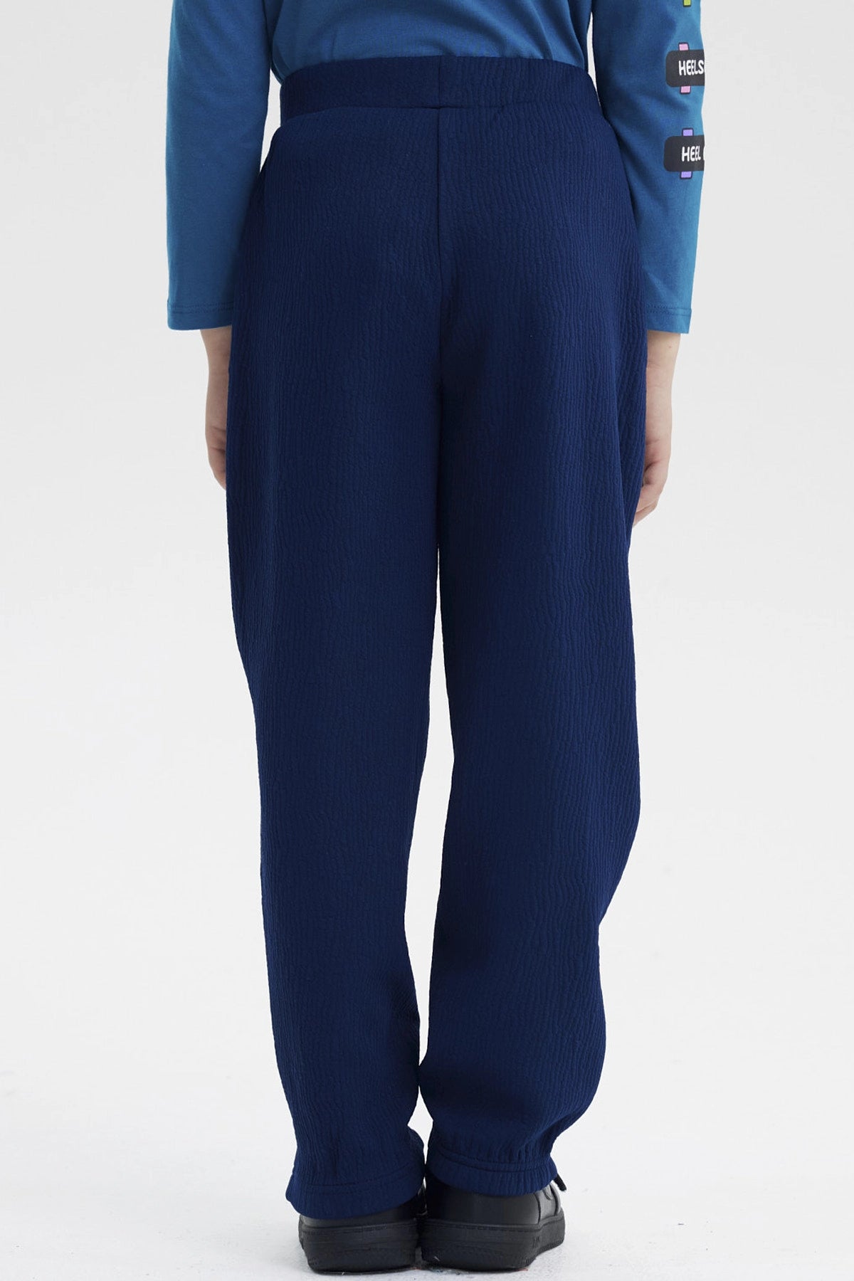 Pantalón buzo pitillo azul oscuro para niño con líneas blancas a los lados prenda lisa