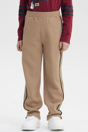 Pantalón buzo pitillo kaki para niño con líneas negras laterales sin estampa visible cómodo y moderno