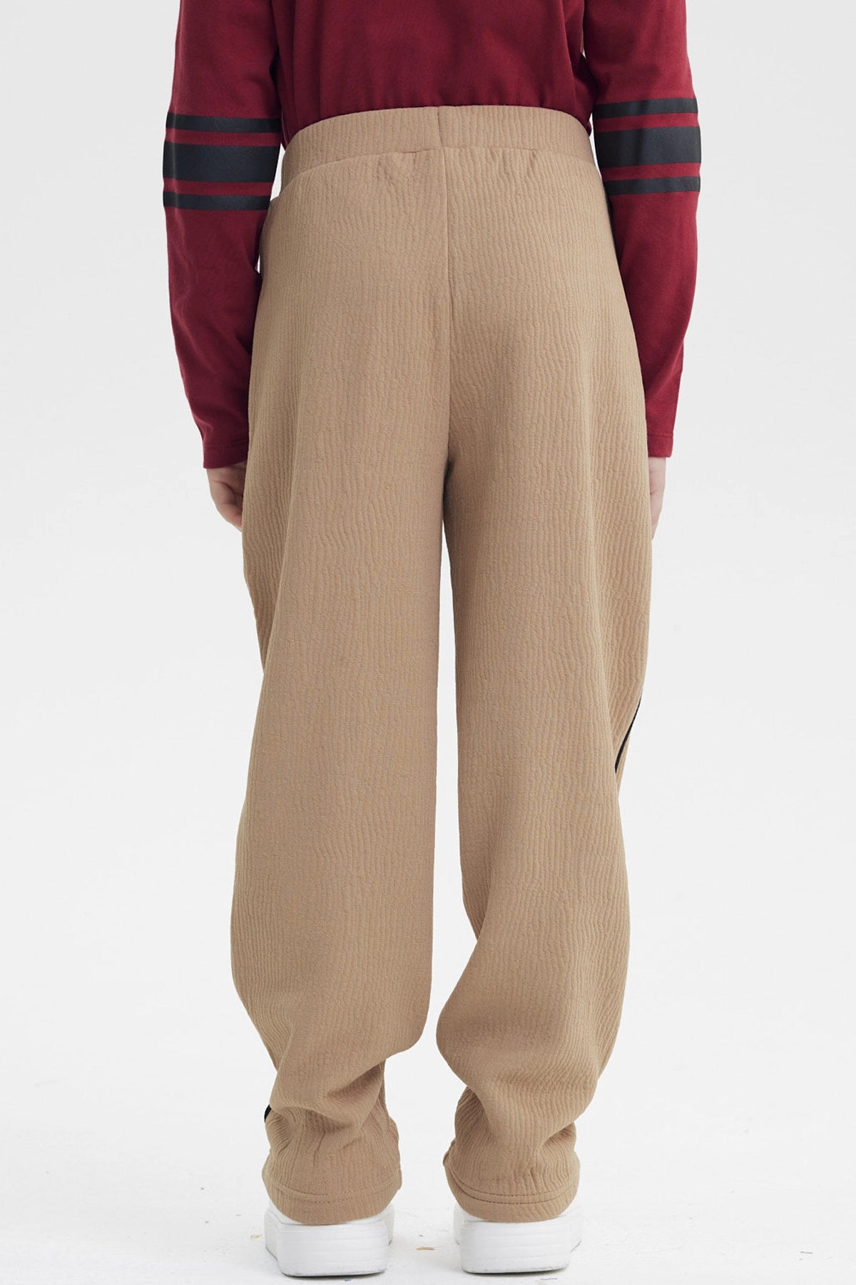 Pantalón buzo pitillo kaki para niño con líneas negras laterales sin estampa visible cómodo y moderno