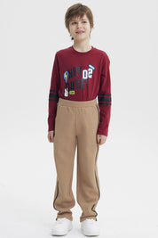 Pantalón buzo pitillo kaki para niño con líneas negras laterales sin estampa visible cómodo y moderno