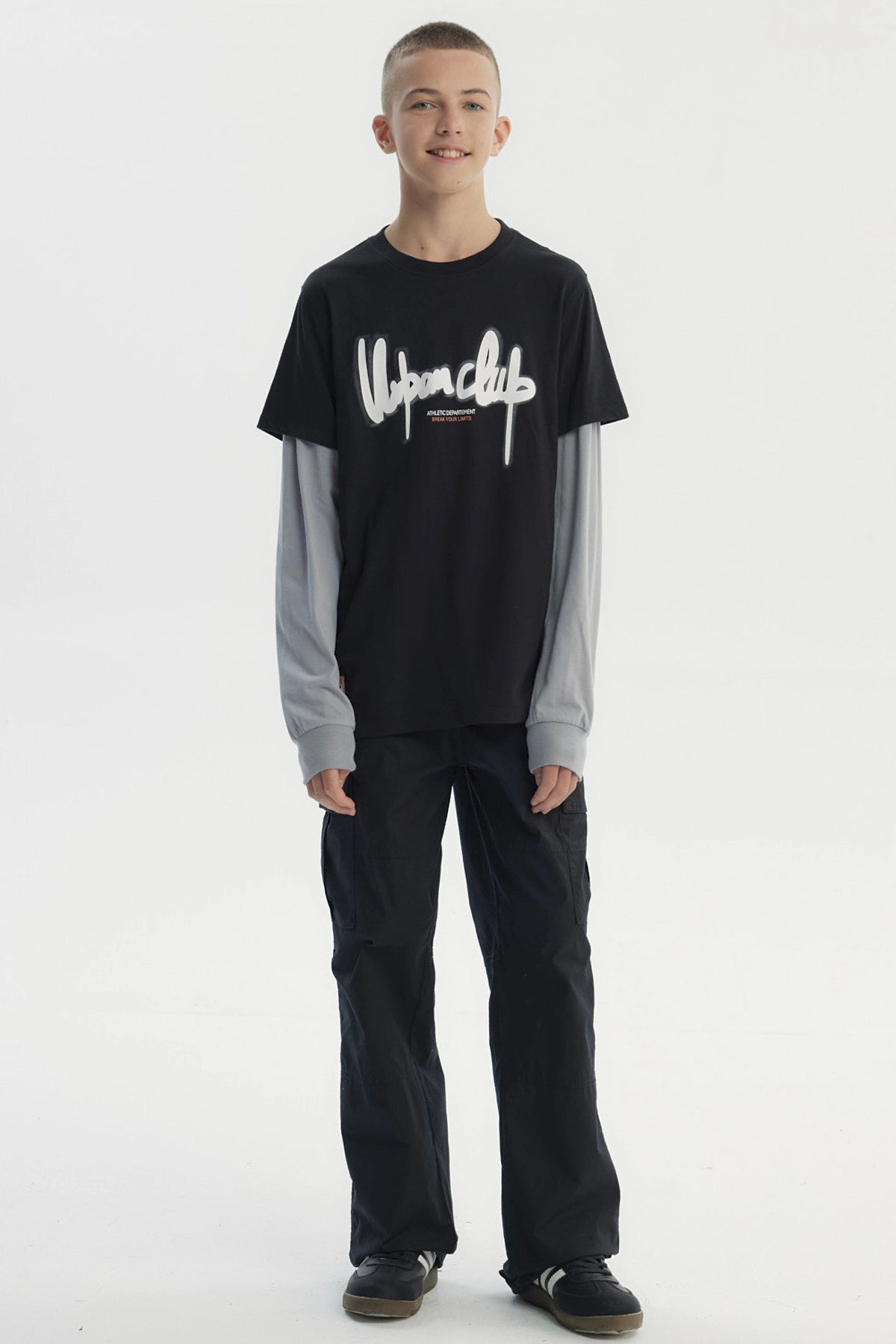 Polera negra slim para niño con estampa Urban Club en el pecho estilo graffiti sobre camiseta gris de manga larga