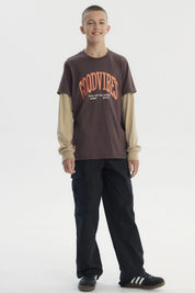 Polera slim café para niño con texto Good Vibes en el frente en estilo gráfico moderno sobre fondo liso