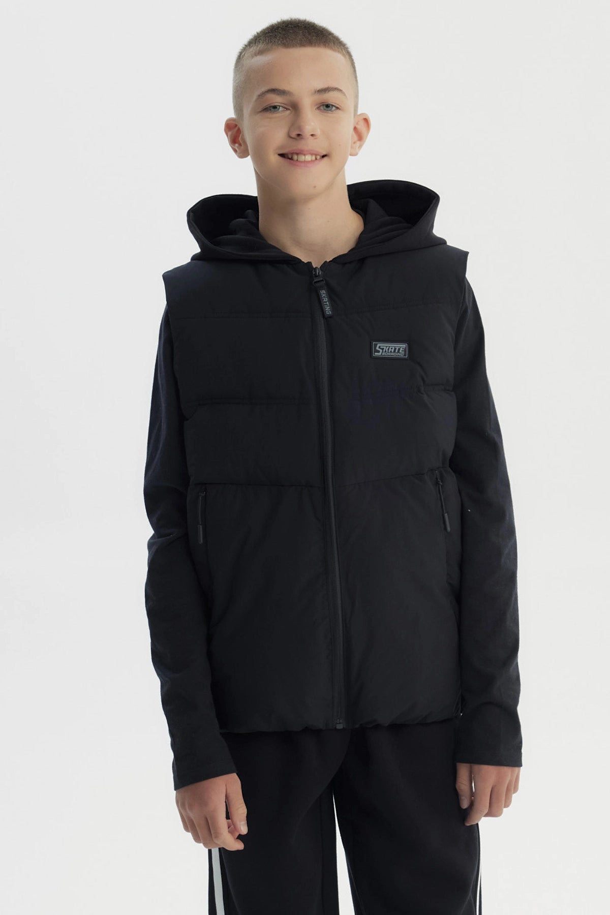 Parka sin mangas negra para niño con capucha y cierre frontal diseño liso ideal para el frío urbano