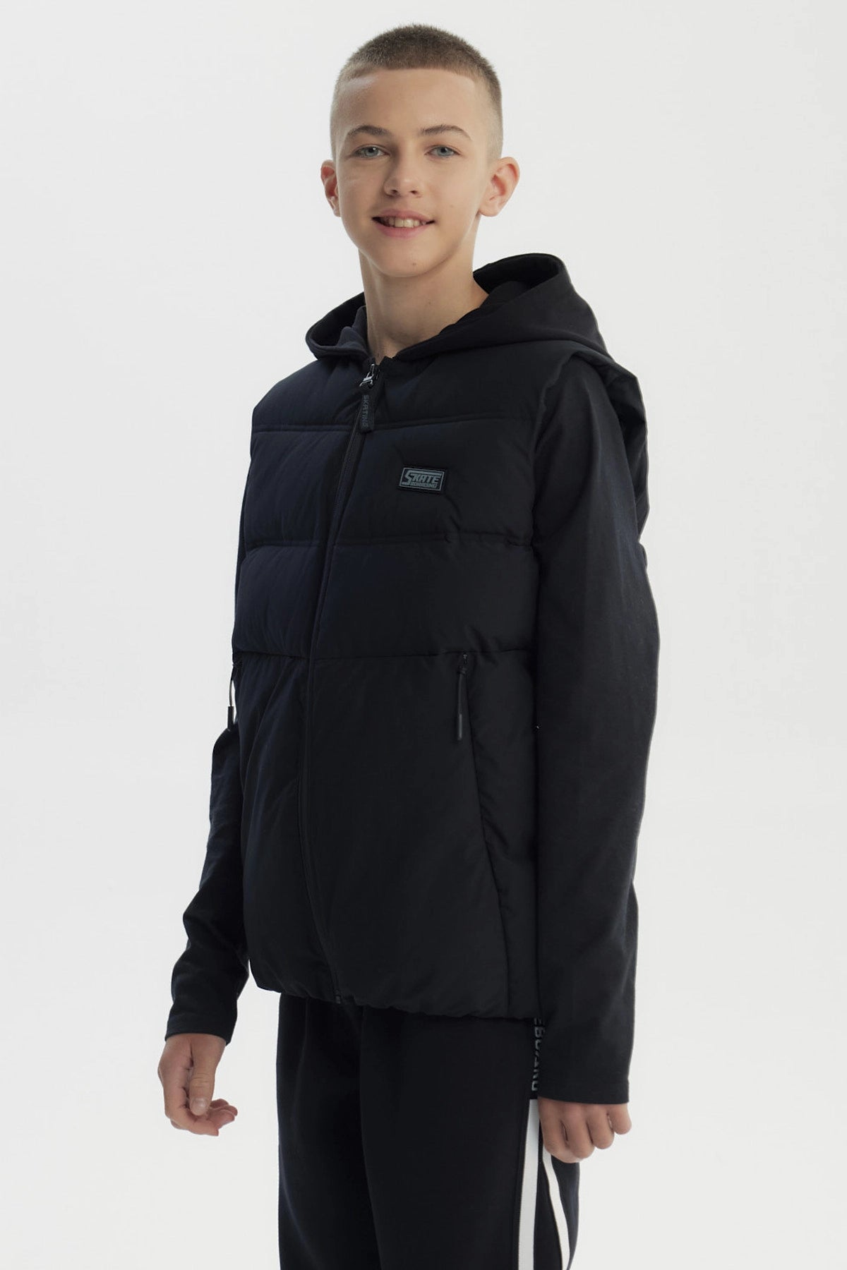 Parka sin mangas negra para niño con capucha y cierre frontal diseño liso ideal para el frío urbano