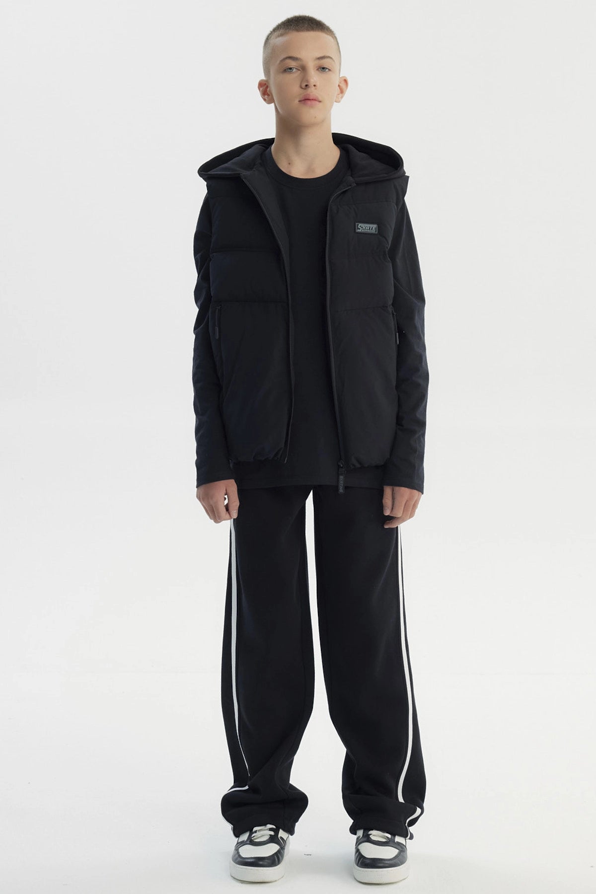 Parka sin mangas negra para niño con capucha y cierre frontal diseño liso ideal para el frío urbano