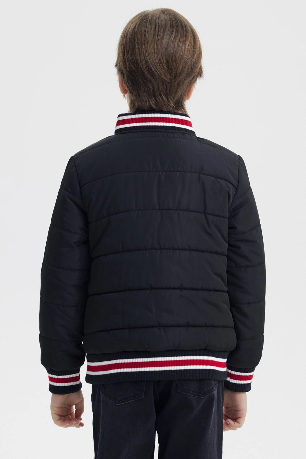 Parka negra para niño con cierre y cuello de rayas rojas y blancas con bordado 83 NYC en el pecho estilo casual