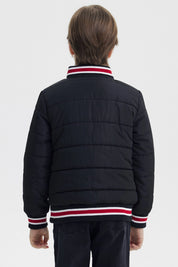 Parka negra para niño con cierre y cuello de rayas rojas y blancas con bordado 83 NYC en el pecho estilo casual