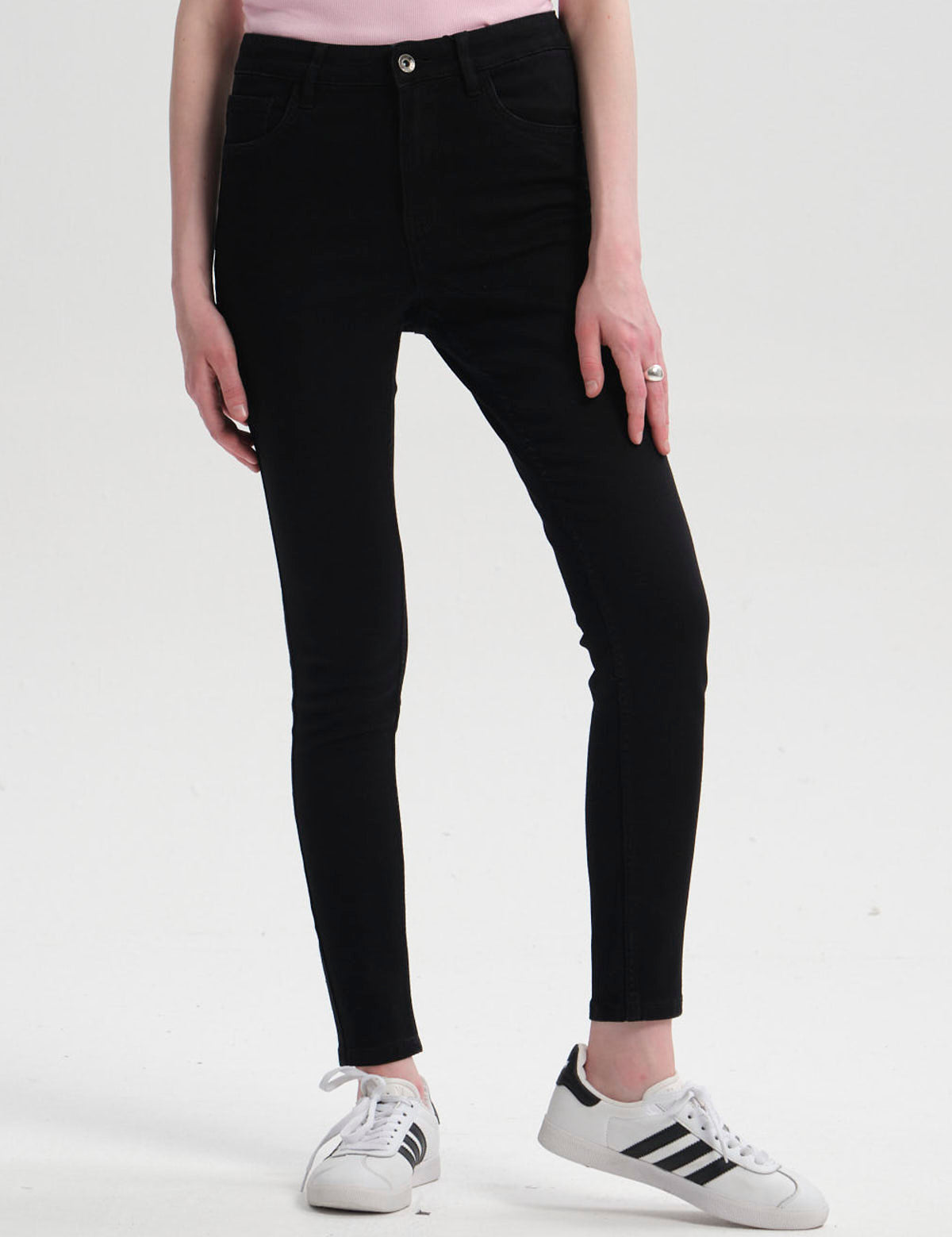 Jeans super skinny de mujer en color negro con diseño ajustado y botón metálico