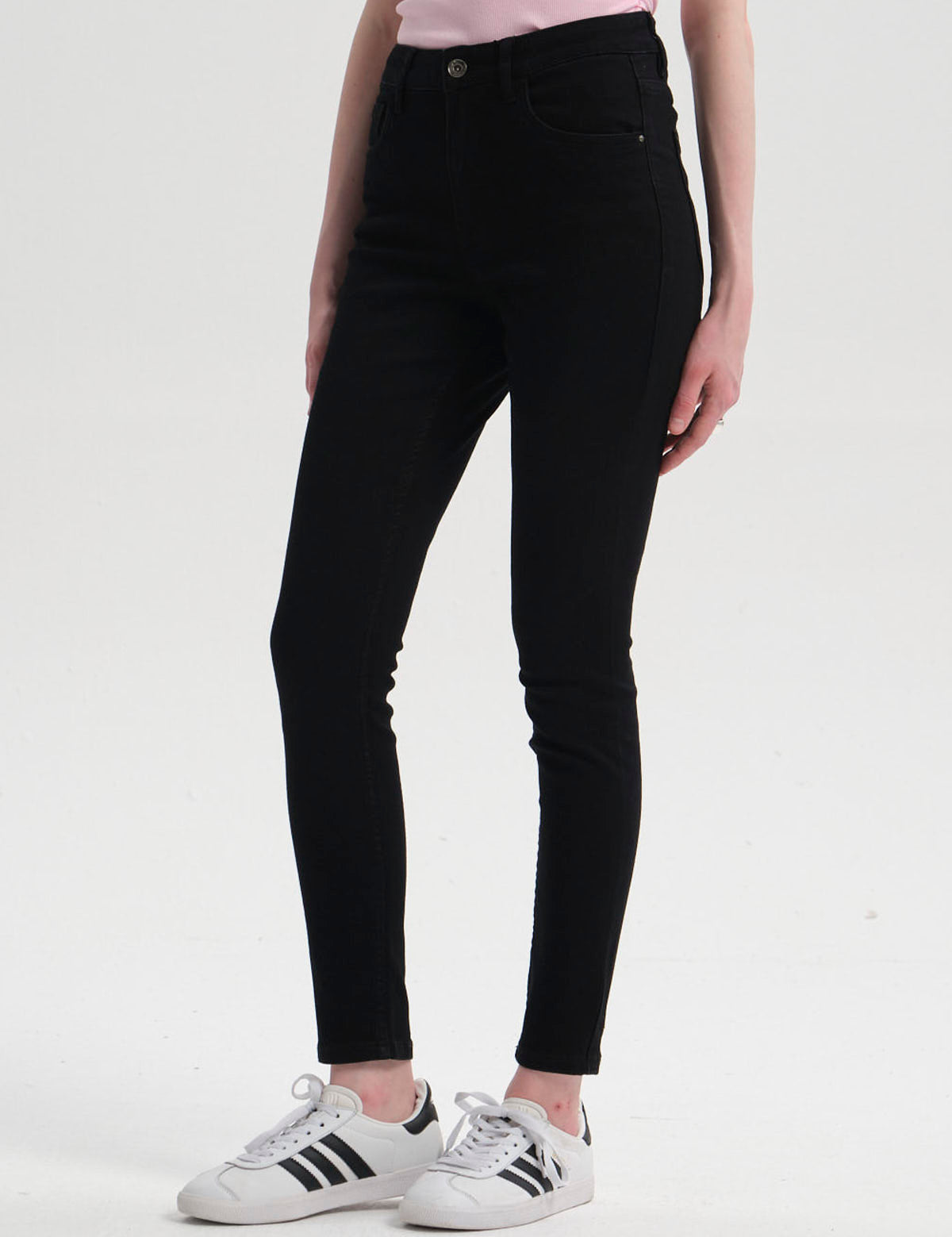 Jeans super skinny de mujer en color negro con diseño ajustado y botón metálico