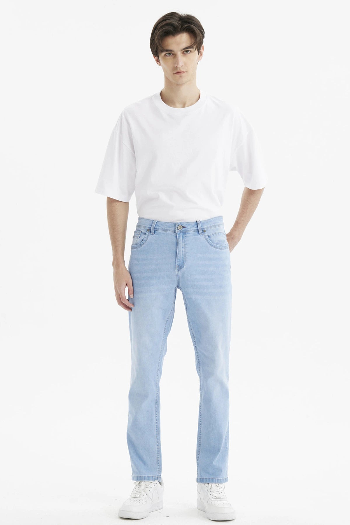 Jeans slim azul claro de hombre con diseño liso y bolsillos delanteros visibles