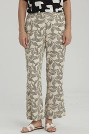 Pantalón pescador beige con estampado de hojas negras grandes estilo gráfico ocupando toda la prenda