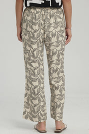 Pantalón pescador beige con estampado de hojas negras grandes estilo gráfico ocupando toda la prenda