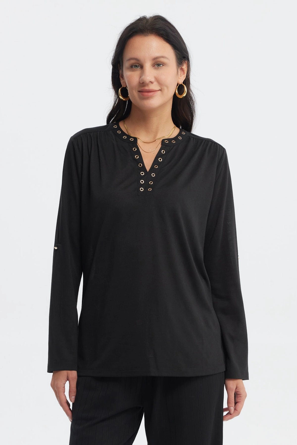 Polera negra de mujer con cuello abotonado y ojales metálicos al frente sin estampa lisa y elegante