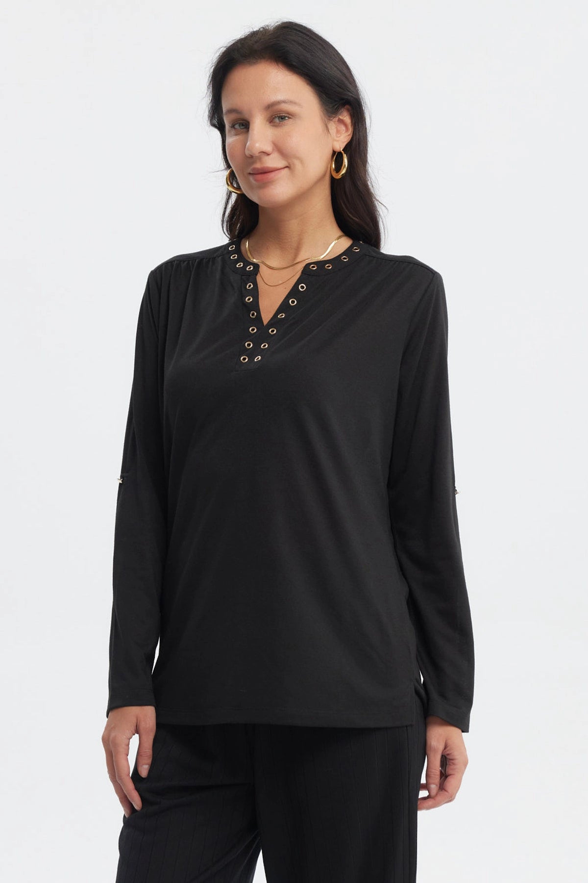 Polera negra de mujer con cuello abotonado y ojales metálicos al frente sin estampa lisa y elegante