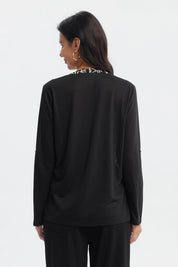 Polera negra con blanco de mujer manga larga con diseño floral en el pecho y cuello abotonado