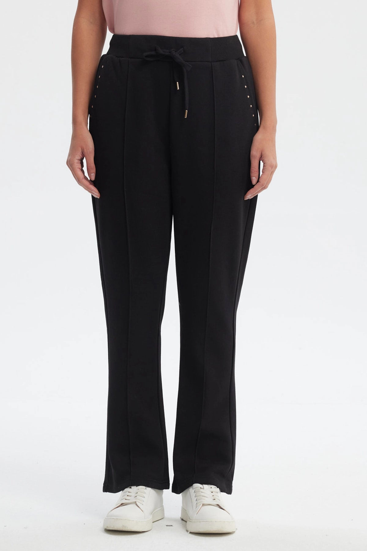 Pantalón buzo flare negro para mujer con cintura elástica y detalle de ojales metálicos en los bolsillos prenda lisa