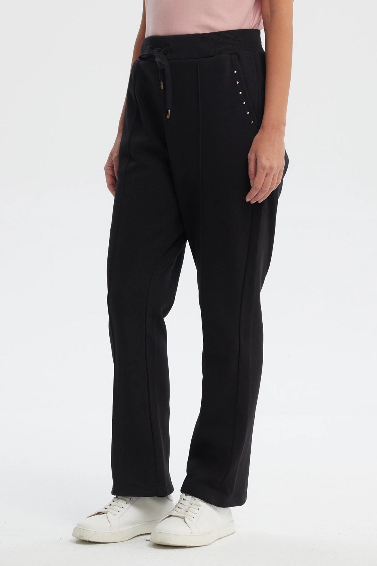 Pantalón buzo flare negro para mujer con cintura elástica y detalle de ojales metálicos en los bolsillos prenda lisa