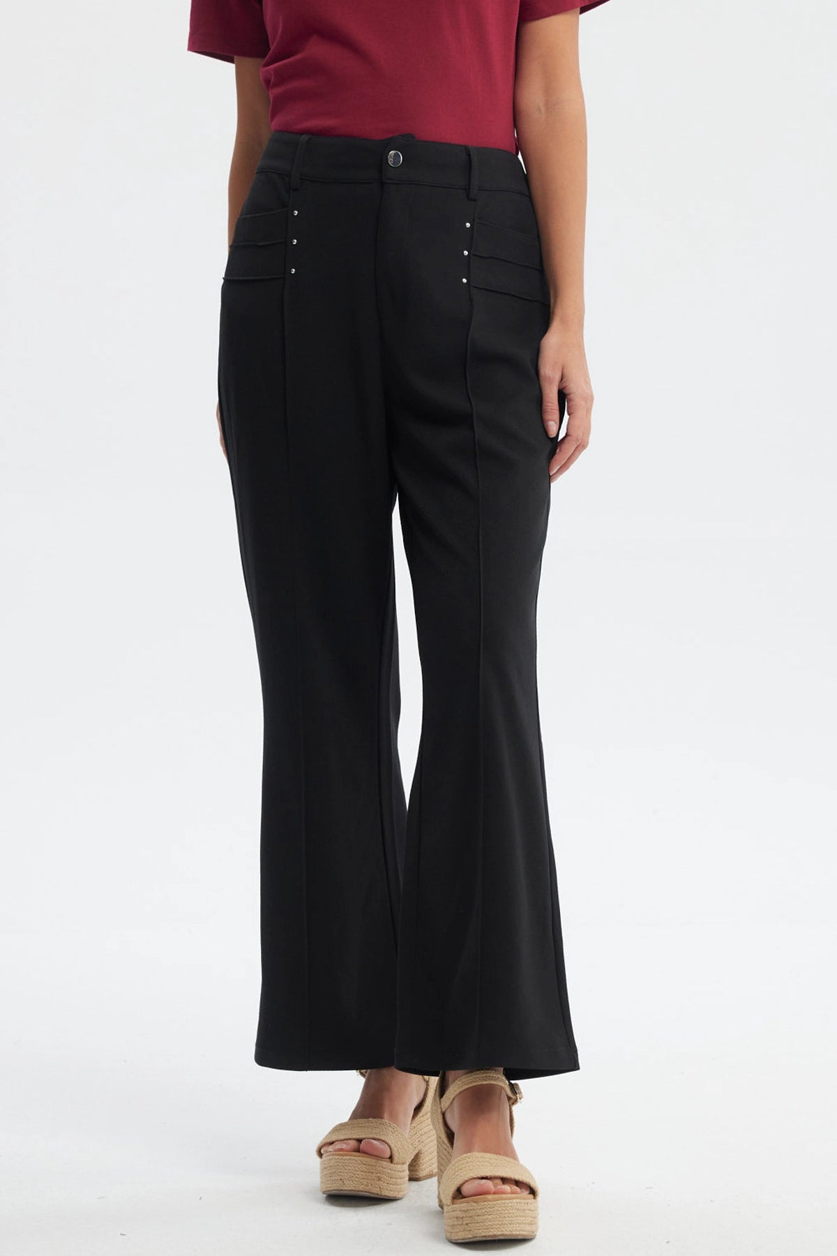 Pantalón largo negro liso para mujer con detalles de botones pequeños en los bolsillos delanteros