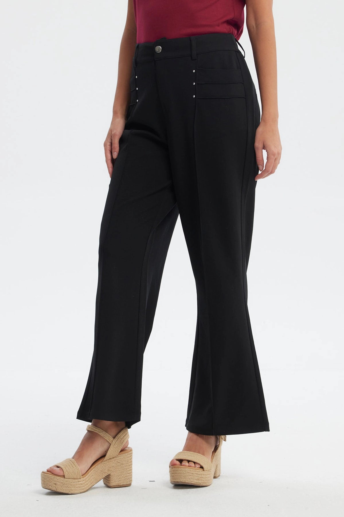 Pantalón largo negro liso para mujer con detalles de botones pequeños en los bolsillos delanteros