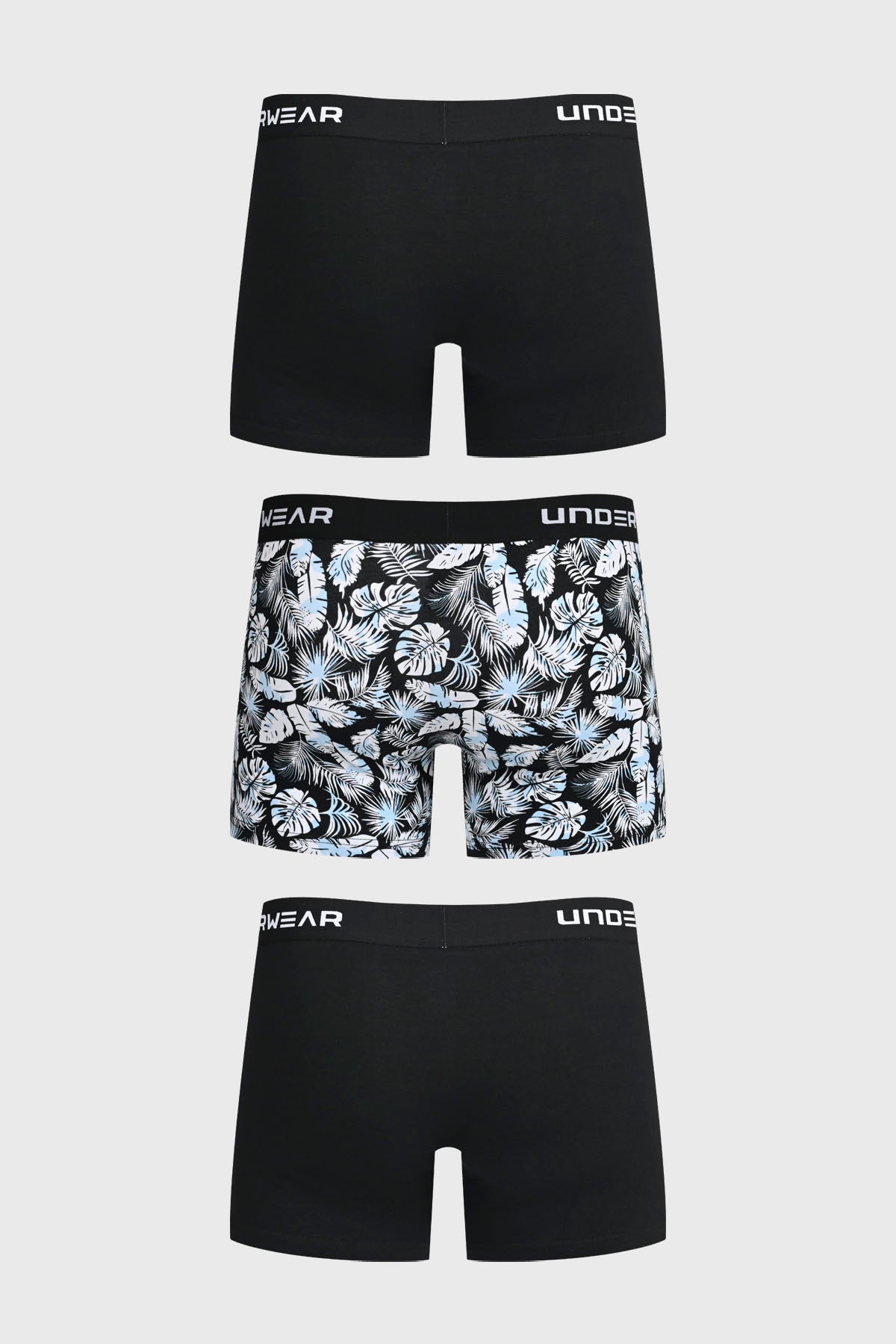 Boxer hombre tripack negro dos lisos y uno con estampado de hojas tropicales en blanco y azul con cinturilla elástica