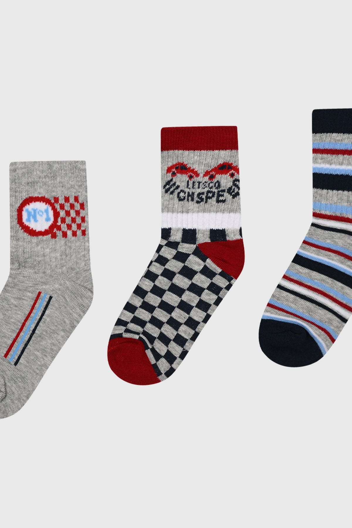 Tripack de calcetines para niño con diseños variados y color rojo predominante uno gris con número y cuadros otro con coches y texto Let's go High Speed y otro con rayas