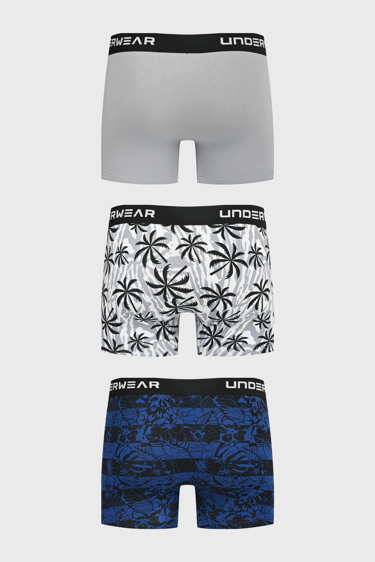 Pack de tres bóxers para hombre con diseño liso gris en el primero estampado de palmeras en el segundo y floral azul en el tercero