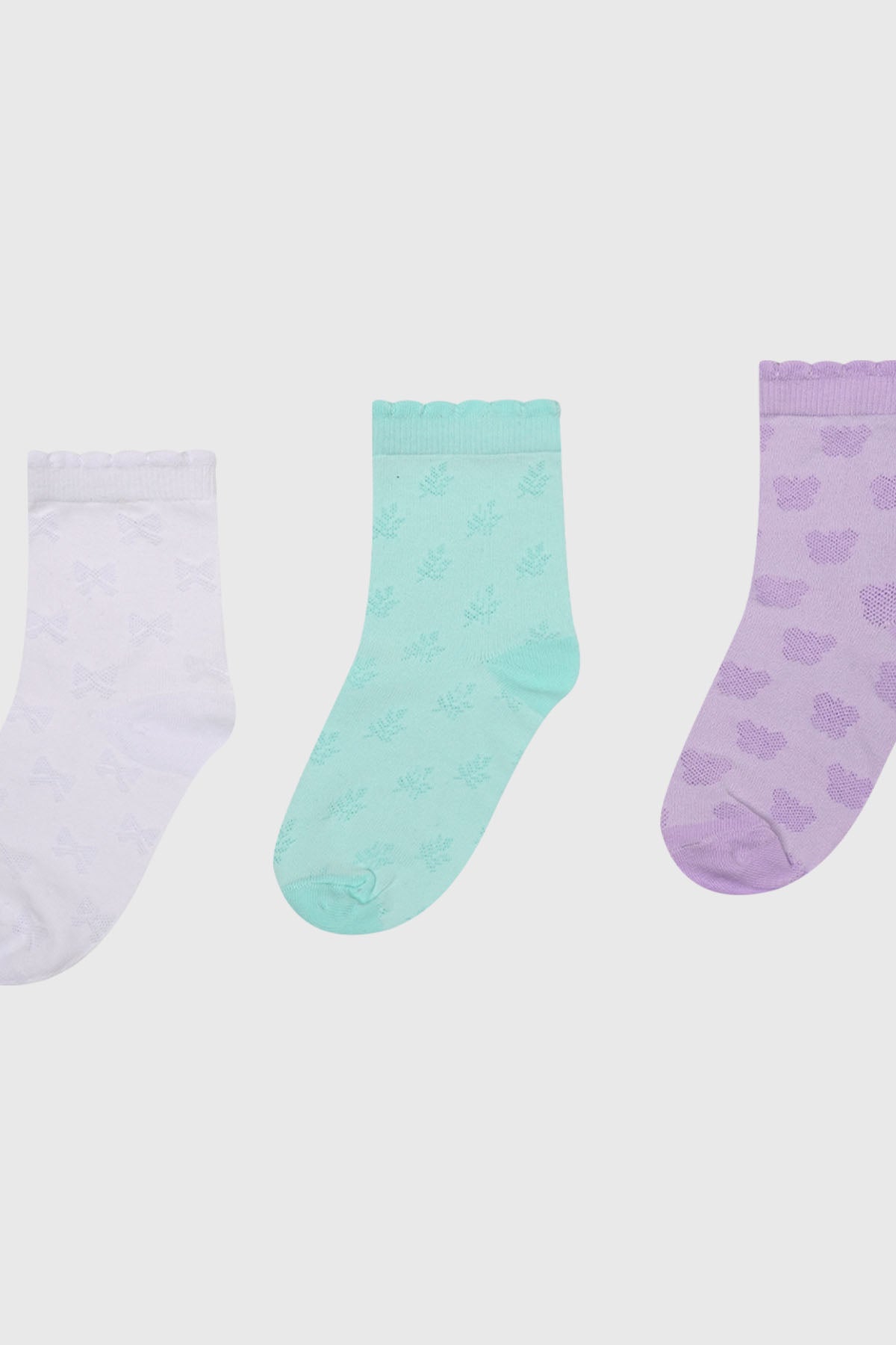 Tripack de calcetines para niña en colores menta blanco y lila con diseños de lazos hojas y nubes en todo el tejido