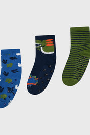 Tripack de calcetines para niño en verde con diseños de dinosaurios y rayas uno azul con huellas otro azul oscuro con dinosaurio en perfil otro verde con rayas
