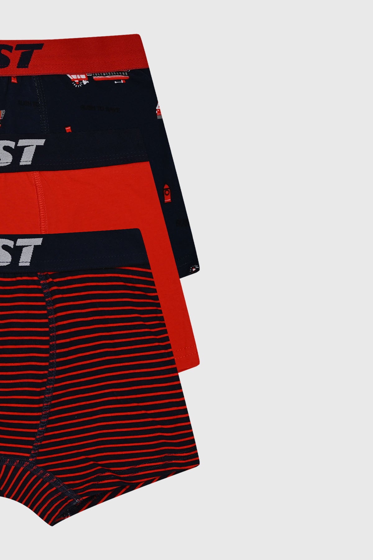 Boxer niño tripack azul marino con diseño de camiones rojos en estilo infantil en una de las prendas