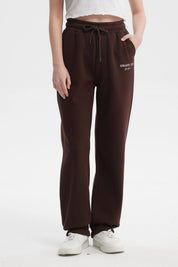 Pantalón jogger café con cintura ajustable y texto 'ROMANTIC CITY' en blanco en la parte superior izquierda