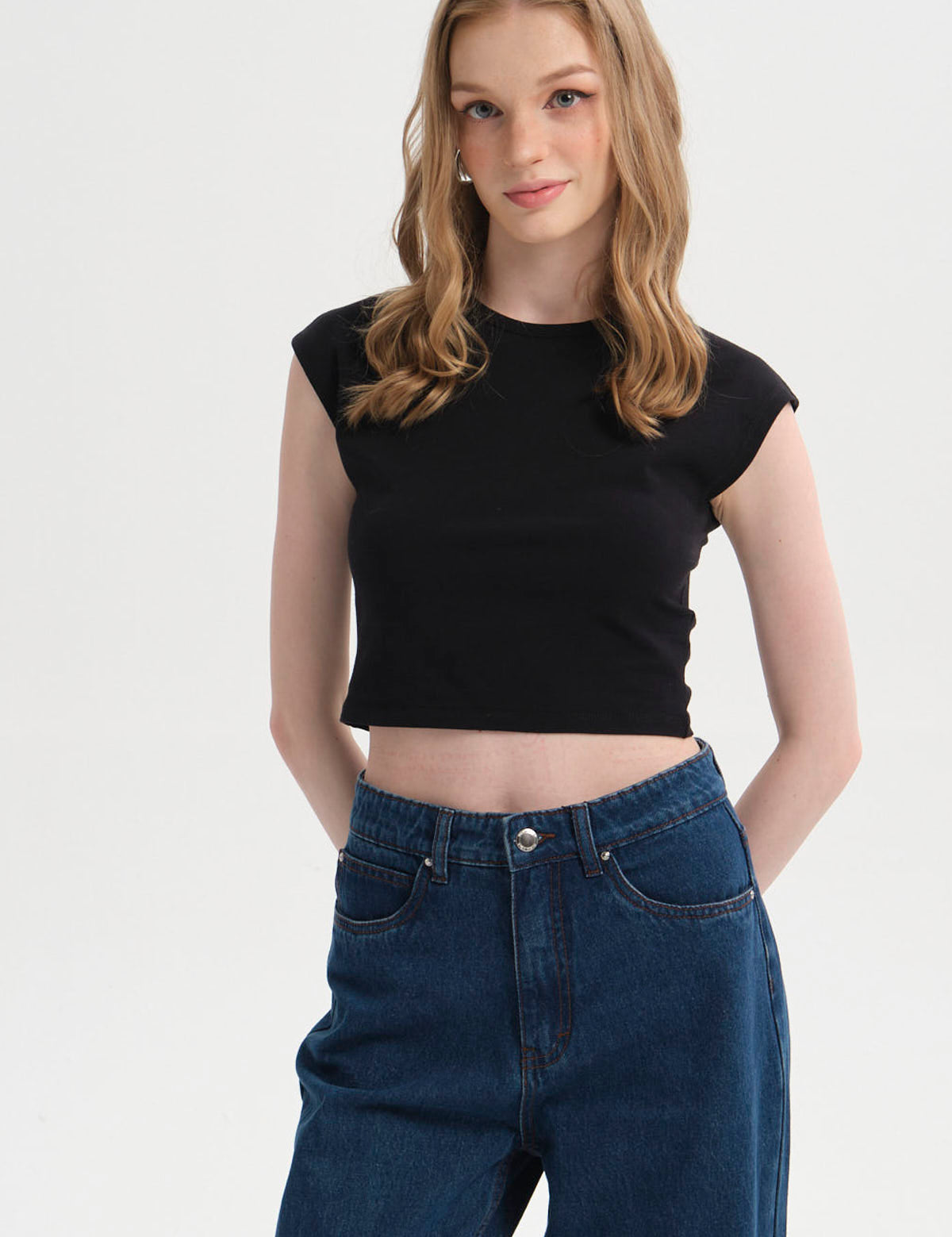 Polera mujer crop negro sin mangas ajustada y lisa de diseño moderno