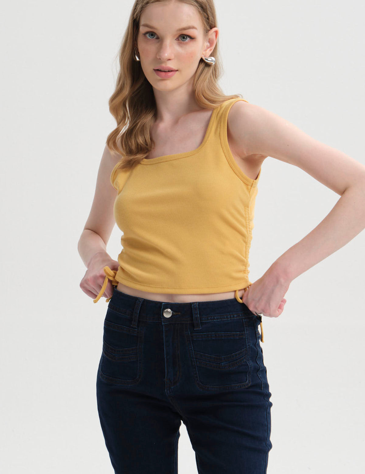 Polera amarilla de mujer sin mangas con recogido lateral visible