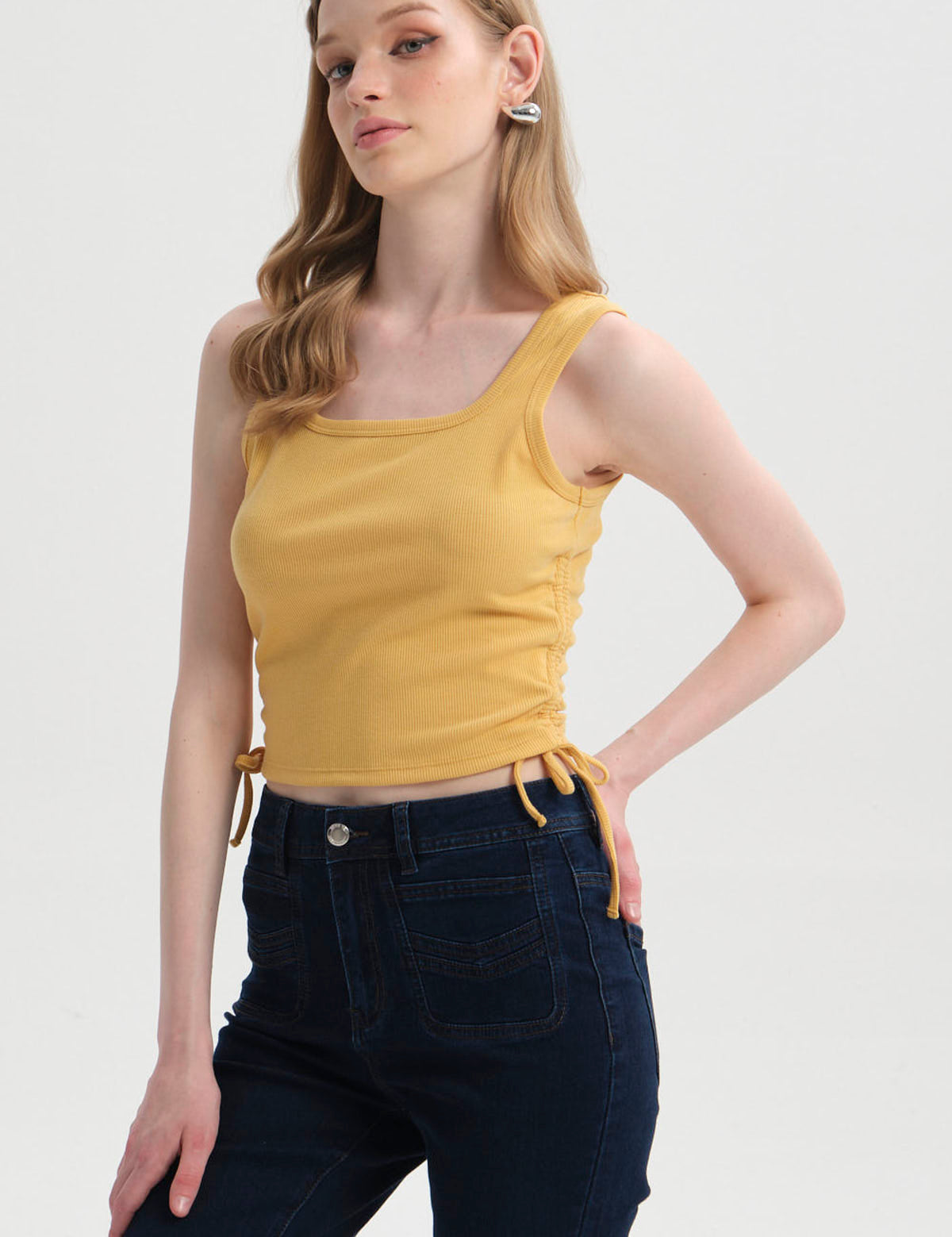 Polera amarilla de mujer sin mangas con recogido lateral visible