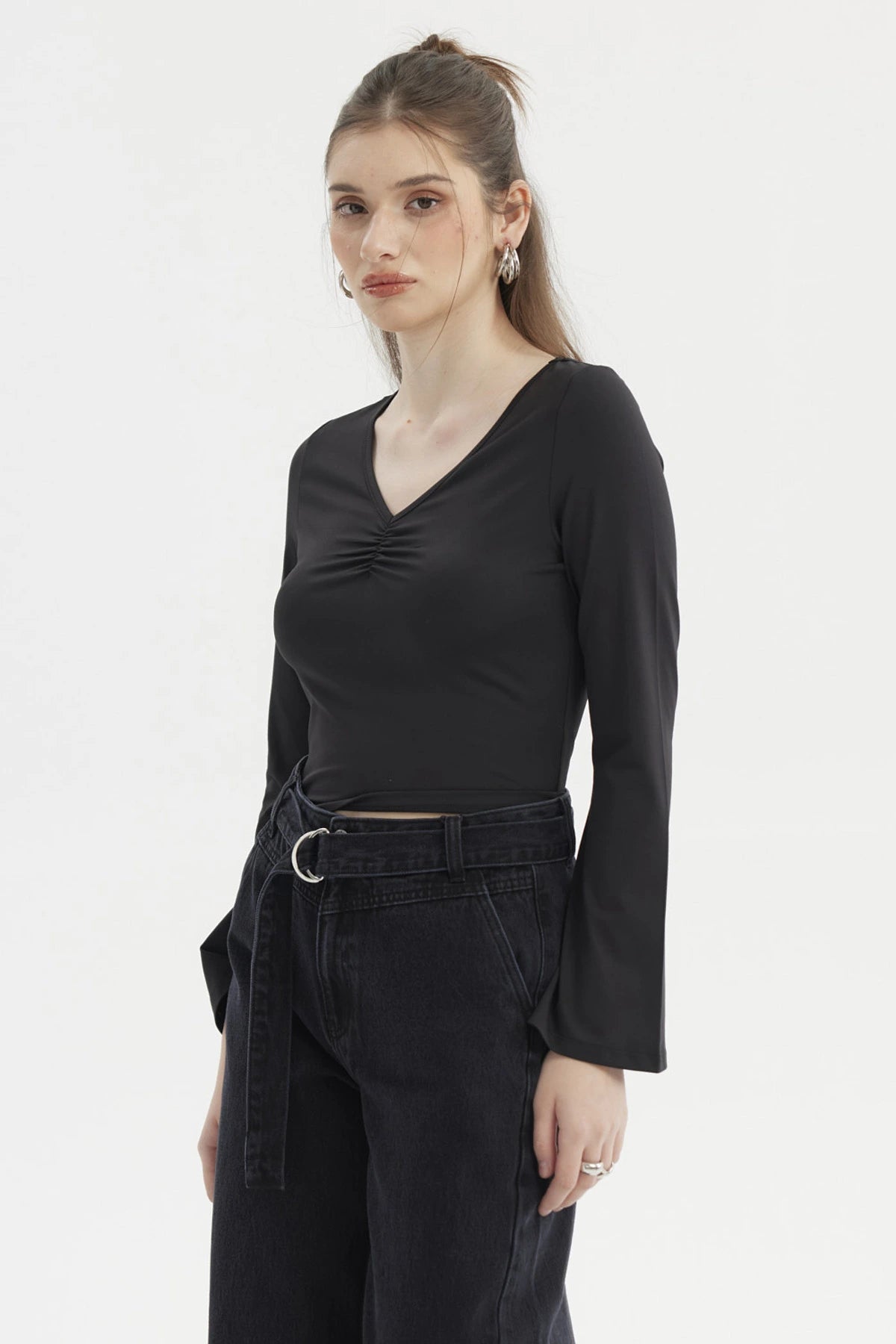 Polera negra de mujer con escote en V y recogido central diseño liso de manga larga ideal para un look casual elegante