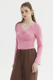 Polera rosa de mujer con escote en V y recogido al frente manga larga y diseño liso ideal para el día a día