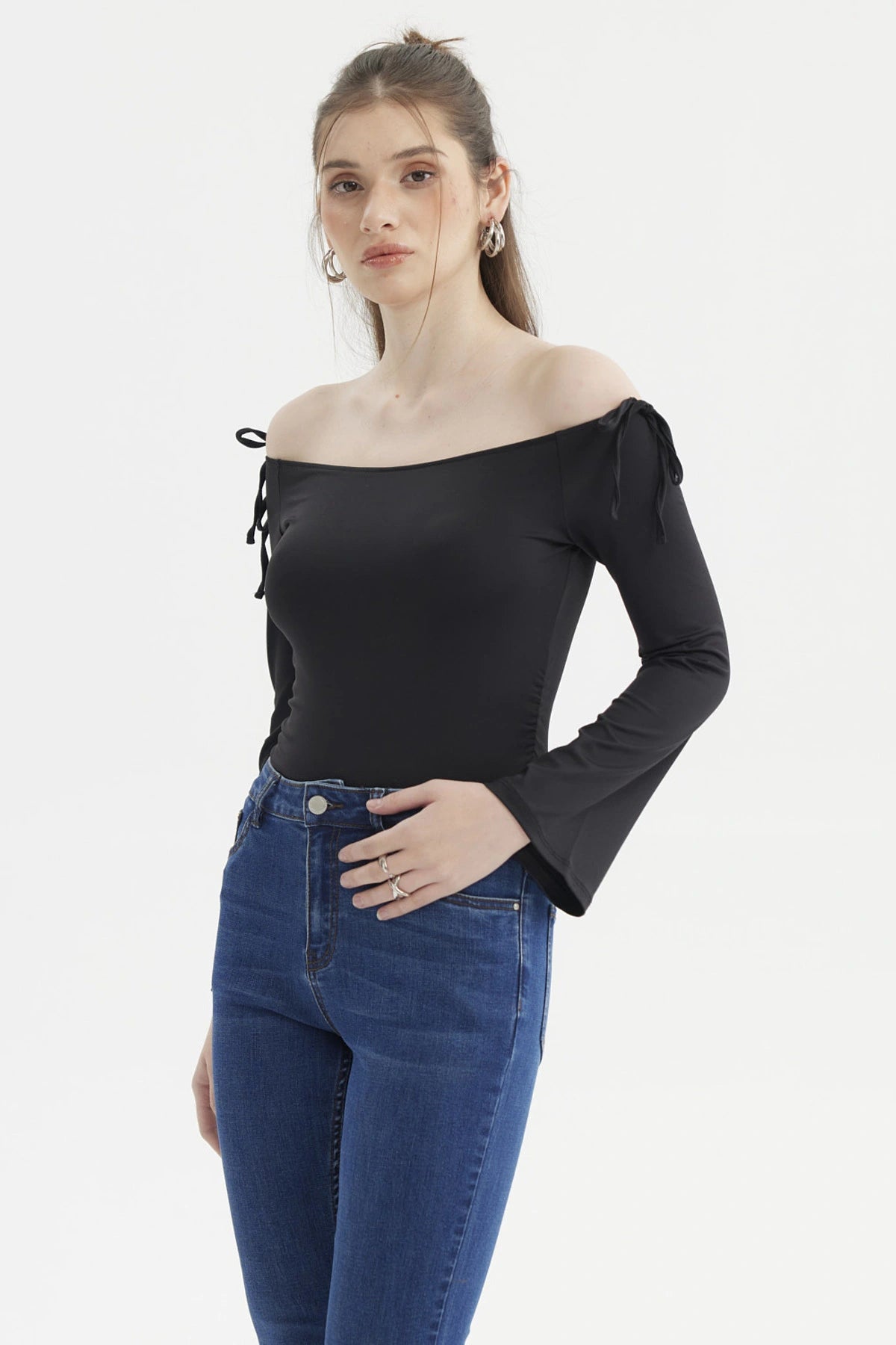 Polera negra de mujer con diseño Bardot hombros descubiertos y lazos en las mangas ajustadas