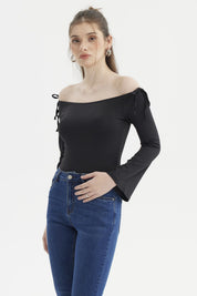 Polera negra de mujer con diseño Bardot hombros descubiertos y lazos en las mangas ajustadas